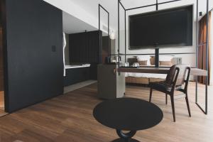 a living room with a tv and a chair and a table at Roannay - Francorchamps in Francorchamps