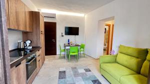 a living room with a green couch and a table at La Casa di Natalie in Girasole