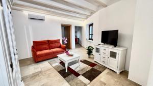 a living room with a red couch and a flat screen tv at La Casa di Natalie in Girasole