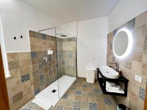 La salle de bains est pourvue d'une douche et d'un lavabo. dans l'établissement casa di natalie, à Girasole