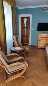a living room with chairs and a table and a television at Dom Sula in Ustrzyki Dolne