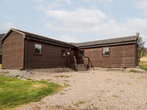 a large wooden house with a yard at Meikle Conval in Keith