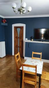 a dining room with a table and chairs and a tv at Dom Sula in Ustrzyki Dolne