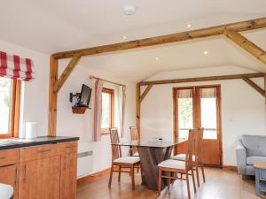 a kitchen with wooden cabinets and a table and chairs at Meikle Conval in Keith
