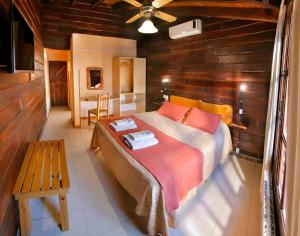1 dormitorio con 1 cama y pared de madera en Posada Pfullendorf - Adults Only en Villa General Belgrano