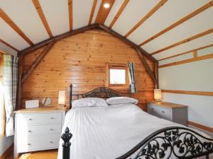 a bedroom with a bed in a wooden house at Ben View in Keith