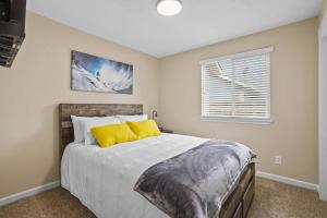 Un dormitorio con una cama con almohadas amarillas y una ventana en Remodeled, Charming Retreat on the City's Doorstep en Boise