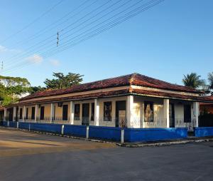 un edificio azul y blanco al lado de una calle en Casarão do Pontal, en Coruripe