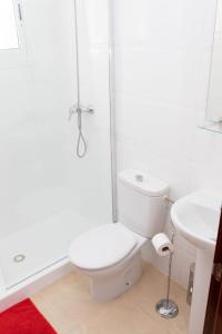 bagno bianco con servizi igienici e doccia di White House ad Arrecife