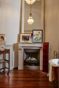 sala de estar con chimenea y 2 fotografías en Casa Howard Firenze - Residenza d'Epoca, en Florencia