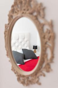 uno specchio che riflette una camera con letto e lampada di White House ad Arrecife