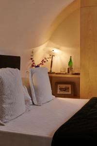 a bedroom with a bed with white pillows and a fireplace at Casa Howard Firenze - Residenza d'Epoca in Florence