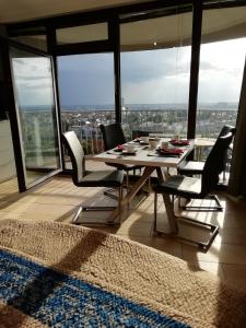 uma mesa de jantar e cadeiras num quarto com janelas em Hotelturm Apartment em Augsburg