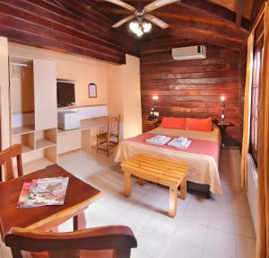 a bedroom with a bed and a table and a desk at Posada Pfullendorf - Adults Only in Villa General Belgrano