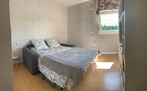 - une chambre avec un lit et un mur en briques dans l'établissement Maison standing, à Muret