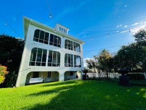 biały budynek na zielonym trawniku w obiekcie Virginia Point INN w mieście Galveston