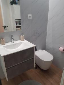a white bathroom with a sink and a toilet at Apartamento Cinema para férias em Esposende in Esposende