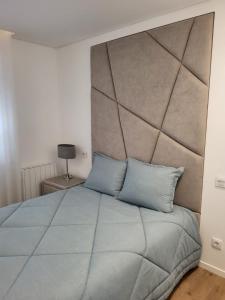 a bedroom with a large bed with a large headboard at Apartamento Cinema para férias em Esposende in Esposende