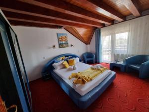 a bedroom with a large bed and a blue couch at Casa Luca in Vama Veche