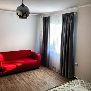 un sofá rojo en una sala de estar con ventana en Kosmajski raj en Nemenikuće