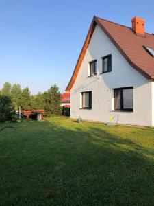 a white house with a yard and a picnic table at Dom wypoczynkowy Zacisze in Filipów