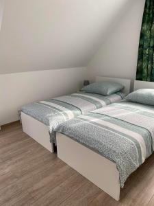2 aparte bedden in een kamer met houten vloeren bij Dom na Borówkowym Wzgórzu in Paleśnica