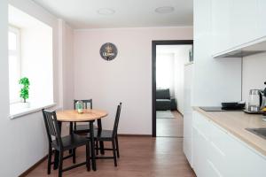 a kitchen and dining room with a table and chairs at Crown Apartment City Center in Ukmergė +13 photos