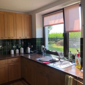 a kitchen with a sink and a window at Dom wypoczynkowy Zacisze in Filipów