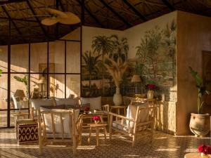 une salle à manger avec des tables et des chaises ainsi qu'une fresque murale. dans l'établissement CASA ABRACADABRA, à Marrakech