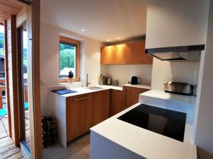 a kitchen with white counter tops and wooden cabinets at Appartement Les Gets, 3 pièces, 4 personnes - FR-1-598-93 in Les Gets