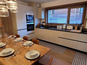 a kitchen with a wooden table with plates and silverware at Appartement Les Gets, 5 pièces, 8 personnes - FR-1-598-99 in Les Gets