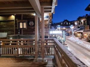 une terrasse en bois avec un bar dans une rue la nuit dans l'établissement Appartement Les Gets, 5 pièces, 8 personnes - FR-1-598-99, aux Gets