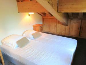 um quarto com uma grande cama branca e tectos em madeira em Appartement Morillon 1100, 4 pièces, 8 personnes - FR-1-412-73 em Morillon