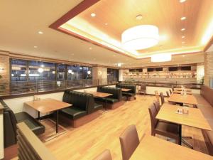 a restaurant with wooden tables and benches and chairs at Richmond Hotel Tokyo Musashino in Musashino