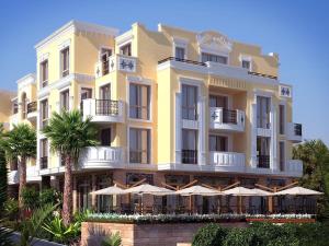a yellow building with umbrellas in front of it at FLORENCE SUITES APART HOTEL in Sveti Vlas