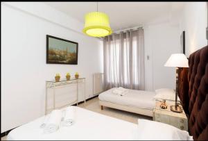 a white room with two beds and a lamp at LUXURY APARTMENT between ANTIBS and CROISETTE in Cannes