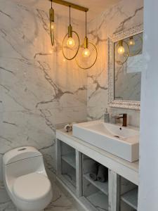a bathroom with a toilet and a sink and a mirror at PLAYA LAGUITO in Cartagena de Indias +29 photos