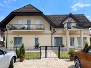 a house with two balconies and a fence at Villa Balifornia in Balatonboglár