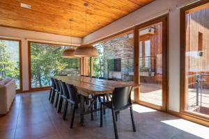 una sala da pranzo con un grande tavolo in legno e sedie di Peñon de Arelauquen Suites del Lago Bariloche Lenga 1C a San Carlos de Bariloche