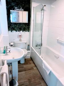 約克的住宿－Cosy Riverside Apartment - FREE PARKING，一间带水槽、浴缸和卫生间的浴室