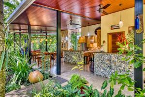an outdoor kitchen and dining area of a house with plants at Villas Piña - Adults only in Puerto Viejo