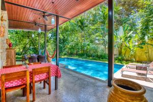 a dining room with a table and a swimming pool at Villas Piña - Adults only in Puerto Viejo