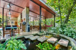 a house in the jungle with a koi pond at Villas Piña - Adults only in Puerto Viejo