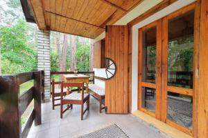 porche con puerta de madera, mesa y sillas en Chata u Tobíka en Holany