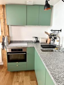 a kitchen with green cabinets and a stove at Triplex In The Heart Of Chamonix in Chamonix-Mont-Blanc