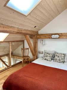 - une chambre avec un lit doté d'une couverture rouge et d'une chaise dans l'établissement Triplex In The Heart Of Chamonix, à Chamonix-Mont-Blanc