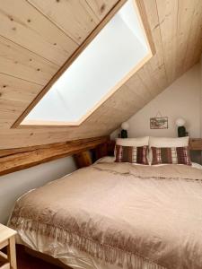 a bedroom with a large bed with a skylight at Triplex In The Heart Of Chamonix in Chamonix-Mont-Blanc