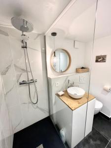 a white bathroom with a sink and a shower at Triplex In The Heart Of Chamonix in Chamonix-Mont-Blanc