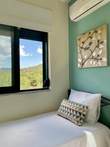 um quarto com uma janela e uma cama com uma almofada em Sunny Villa em Kissamos