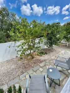 a patio with a table and two chairs and trees at Sunny Villa in Kissamos